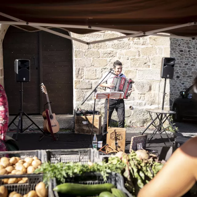 Concert de Mathilde, Compagnie la voix dans ma tête,  au Marché de Saint Genest Sur Roselle. Ce marché regroupe producteurs locaux, commerçants et animations, le dimanche matin à Saint Genest sur Roselle, Communauté de Communes Briance Sud Haute Vienne, Haute Vienne, France.  Août 2023.